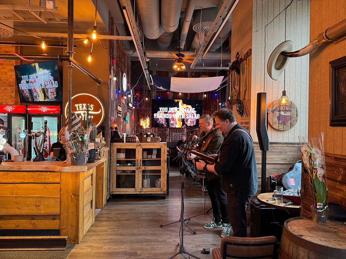 Integration av livemusik i restaurang med Klipsch-högtalare och digital skyltning.